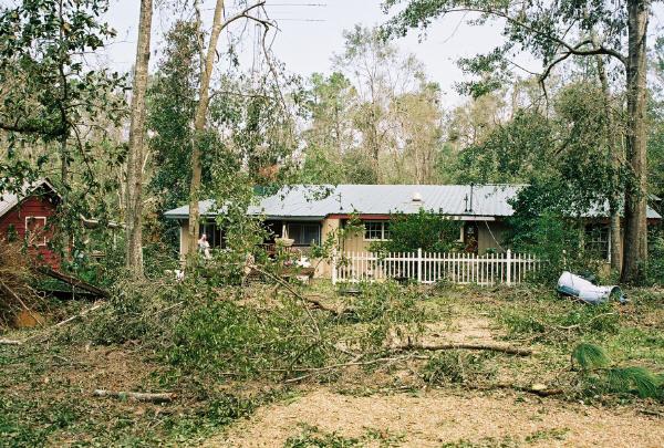 home_30Aug_10.jpg - The front of our house. At first I was relieved when I didn't seen any trees on top of the roof, but as we got closer Kathy pointed out the water line.