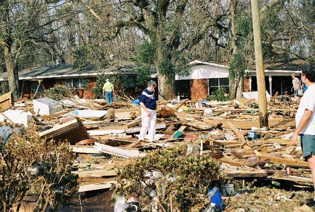 moms_house11.jpg - My poor mom was totally lost. It took us awhile to even find the exact spot of her house. Here she is walking over debris covering the street.